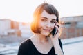 Young pretty woman talks on phone looks in camera Royalty Free Stock Photo