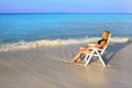 Young pretty woman tans in beach chair in ocean Royalty Free Stock Photo