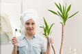 A young pretty woman with a towel on her head in a bright bathroom with a toothbrush and paste in her hands