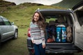 Young pretty woman traveler standing near open back door of the car Royalty Free Stock Photo