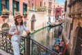 young pretty woman traveler standing at venice bridge cross canal