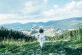 Young pretty woman walking by mountain peak