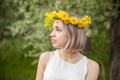 Young pretty woman wearing flowers wreath in spring park outdoor Royalty Free Stock Photo