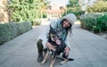 Young and pretty woman in a white cap hugs and kisses her dog with one eye of each color. Love between owner and dog Royalty Free Stock Photo