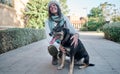 Young and pretty woman in a white cap hugs and kisses her dog with one eye of each color. Love between owner and dog Royalty Free Stock Photo