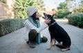 Young and pretty woman in a white cap hugs and kisses her dog with one eye of each color. Love between owner and dog Royalty Free Stock Photo