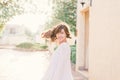 Young pretty woman in white dress is walking in old city street in sunset. Royalty Free Stock Photo