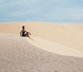 Young pretty woman in white sand dunes like a goddes of darkness Royalty Free Stock Photo