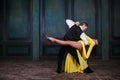 Young pretty woman in yellow dress and man dance tango