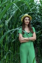 Young pretty woman in the yellow hat among the corn plants in the corn field in summer season. Bereza, Belarus. Royalty Free Stock Photo