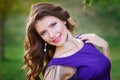 Young pretty women with long windy hair in elegant violet dresses standing on green grass Royalty Free Stock Photo