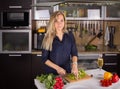 Young pretty young woman cooking salad in kitchen Royalty Free Stock Photo