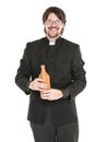 Young priest with bottle of alcohol isolated Royalty Free Stock Photo