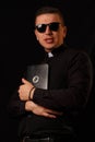 Young priest holding and crypto bible with bitcoin logo Royalty Free Stock Photo