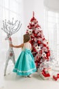 Young princess in a smart dress at christmas near a Christmas tree.little girl and christmas decoration.Dress of the