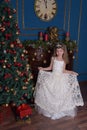 Young princess in a white dress with a tiara on her head at the Christmas tree Royalty Free Stock Photo