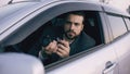 Young private detective man sitting inside car and photographing with dslr camera Royalty Free Stock Photo