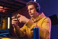 Young pro gamer playing in online mobile video games in neon coloured room Royalty Free Stock Photo