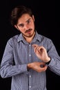 Young professional adult doing cuff button up on blue and white check business shirt