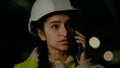 Young professional arabian woman technical engineer builder architect in uniform and hardhat talking mobile phone with Royalty Free Stock Photo