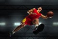 Young professional basketball player in action, motion isolated on black background, look from the bottom. Concept of Royalty Free Stock Photo