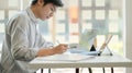 Young professional businessman is thinking of his future project with a laptop on the table in the comfortable office Royalty Free Stock Photo