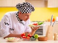 Young professional cook preparing salad at kitchen Royalty Free Stock Photo