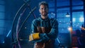 Young Professional Fabricator in Safety Glasses and Apron Gently Smiles at the Camera with Crossed