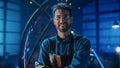 Young Professional Fabricator in Safety Glasses and Apron Gently Smiles at the Camera with Crossed