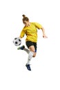 Young professional female football player in motion, playing football, soccer, hitting ball in a jump isolated over Royalty Free Stock Photo