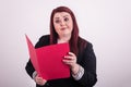 Young professional female holding an open a red file folder pointing at it