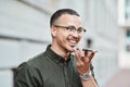 Young, professional and happy businessman using a phone outdoors. Positive male smiling while speaking on a call Royalty Free Stock Photo