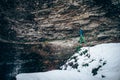 Young professional male climber is preparing to climb. Beautiful texture of rocks on background.