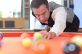 Young professional man playing billard in club