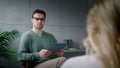 A young professional psychotherapist conducts an interview with a patient in the office