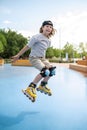 Young professional roller-skater performing rollerblading trick outdoors