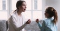 Young professional speech therapist teaching little child girl.