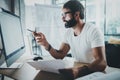 Young professional web designer wearing eye glasses working at modern loft studio-office with desktop computer.Blurred