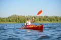 Young Professional Woman Kayaker Paddling Kayak on River under Bright Morning Sun. Sport and Active Lifestyle Concept
