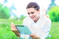 young professional woman laying down on green grass in a city park Royalty Free Stock Photo