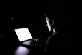 Young programer student run assignment with laptop alone at midnight in dark room Royalty Free Stock Photo