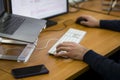 Young programmer typing on a freestanding white keyboard on a wooden table in front of two monitors Royalty Free Stock Photo