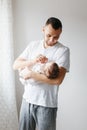 Young proud Caucasian father playing with newborn baby. Man parent holding rocking child daughter son on hands. Authentic Royalty Free Stock Photo