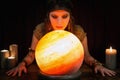 Young Psychic is telling the future, crystal ball and candles in