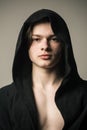 Young pugilist in black hood isolated on gray background. Handsome fighter before going to boxing ring. Muscular guy Royalty Free Stock Photo