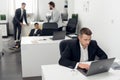 A young purchasing Manager in a black suit makes a large online order via an intranet in a laptop for his company