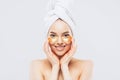 Young pure beautiful gentle woman with a towel on head standing naked isolated looking camera take care of her skin with under eye