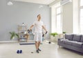 Young purposeful man at home doing sports strength training using rubber resistance band. Royalty Free Stock Photo