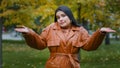 Young puzzled upset hispanic woman standing outdoors in park shrugging shoulders doubtful looking at camera unsure does Royalty Free Stock Photo