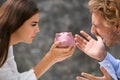 Young quarreling couple with piggy bank on grey background Royalty Free Stock Photo
